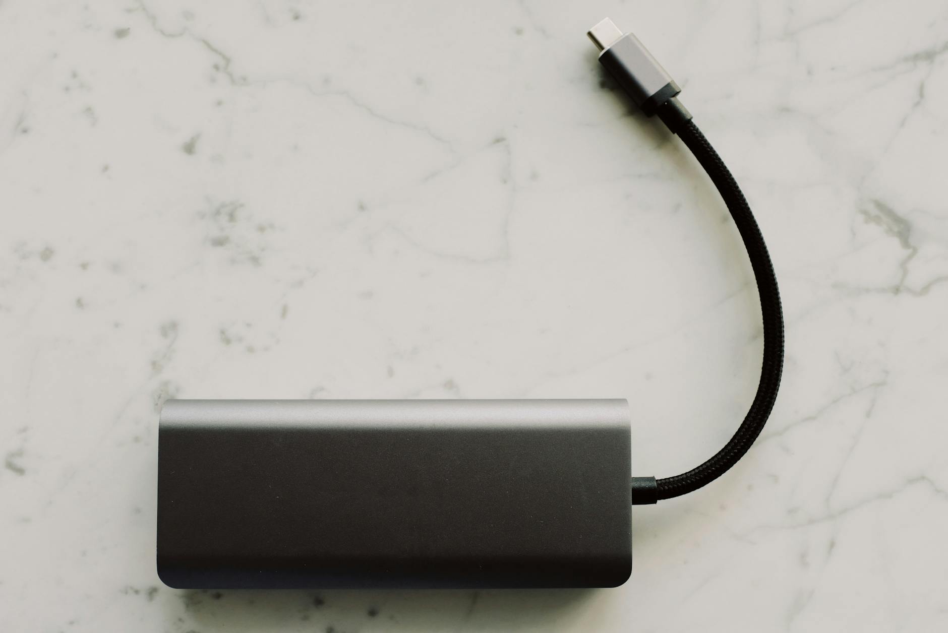 Powerbank z kablem USB-C leży na marmurowym blacie